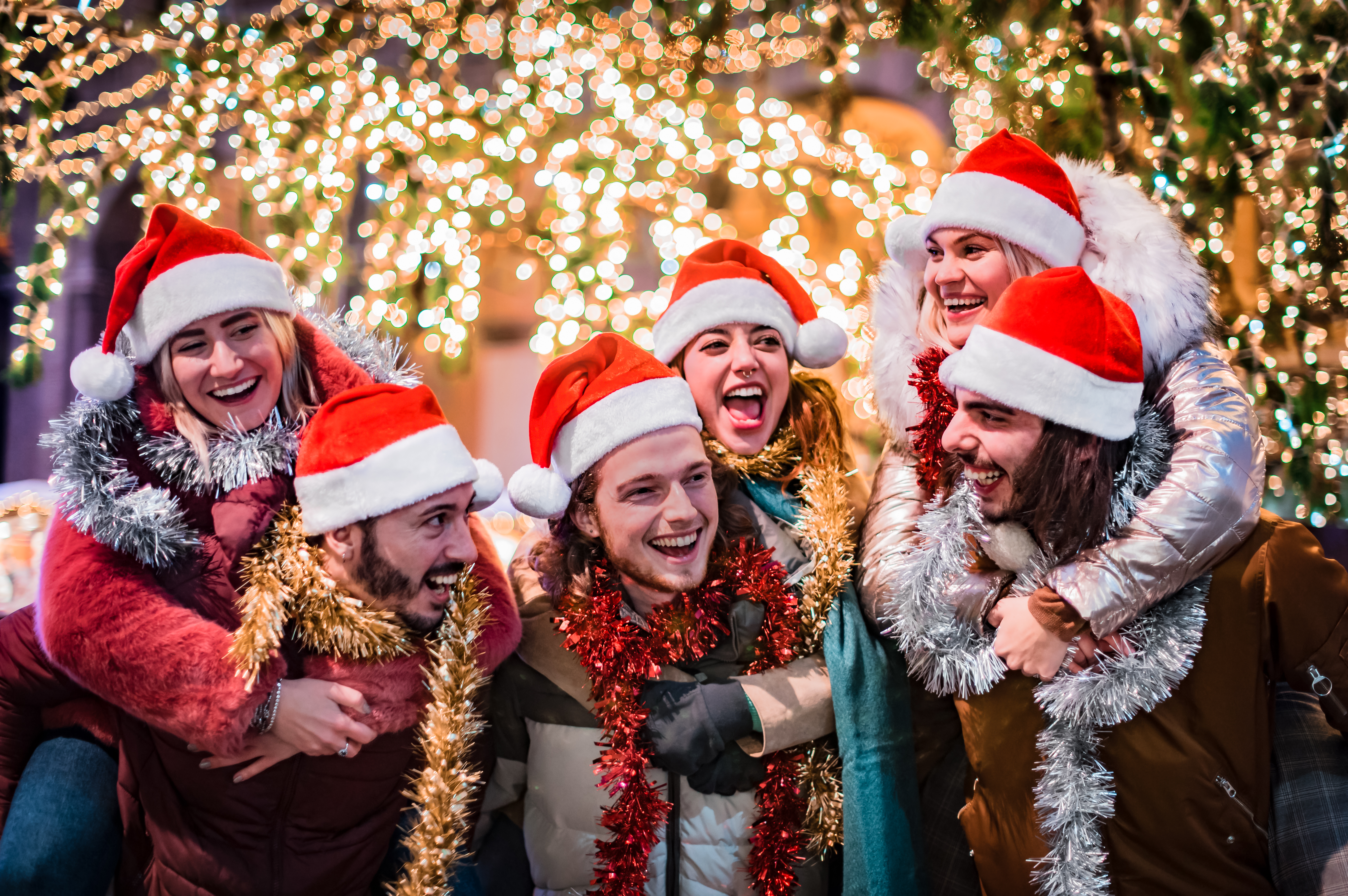 Happy group of friends wearing Santa Claus hat and celebrating C